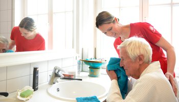 Pflegerin hilft älterem Herren beim Waschen | © Heinz von Heydenhaber